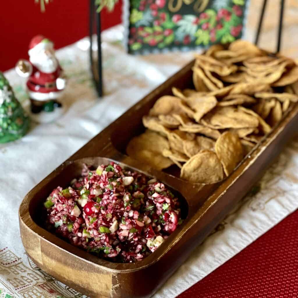 A bowl of jalapeno cranberry salsa and chips.