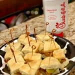 A plate of chick fil a mini sandwiches.