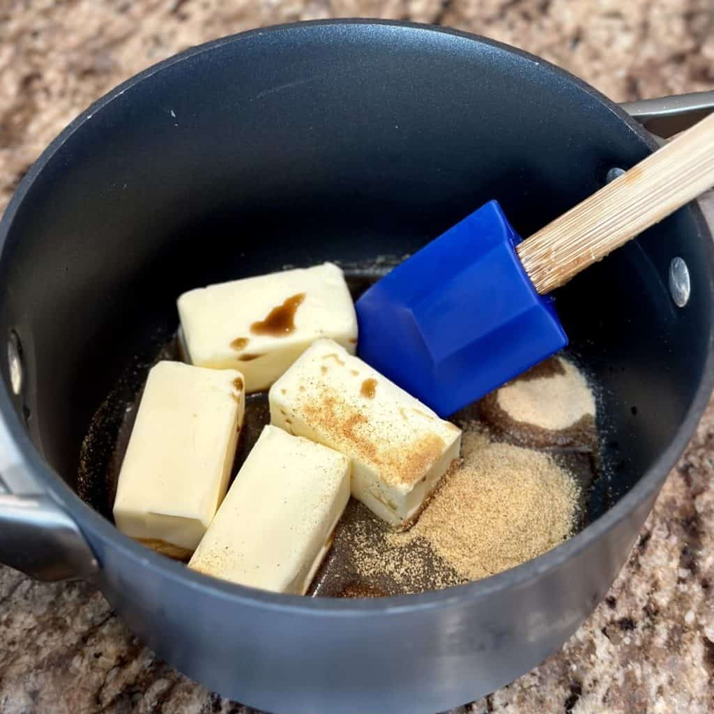 Mixing together the butter sauce ingredients for chex mix in a sauce pan.