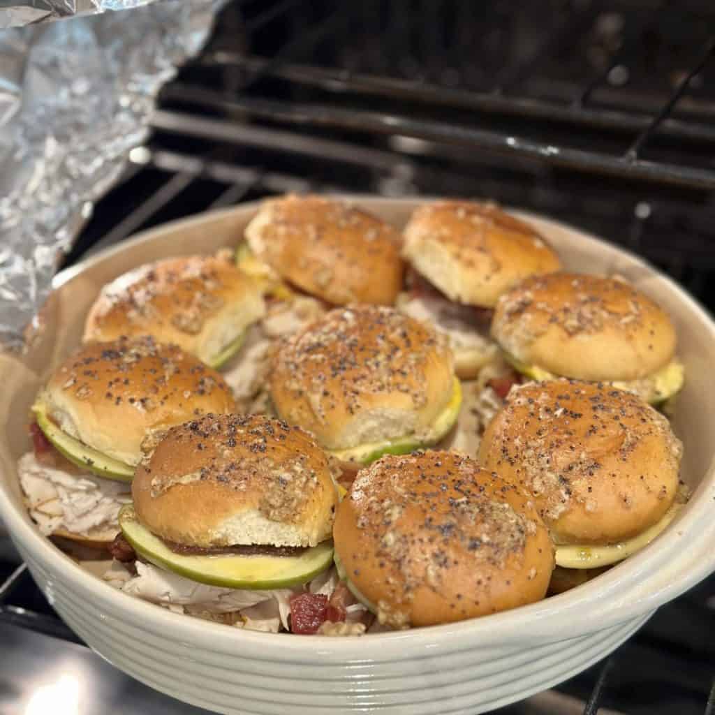 Uncovering aluminum foil from sliders in the oven.