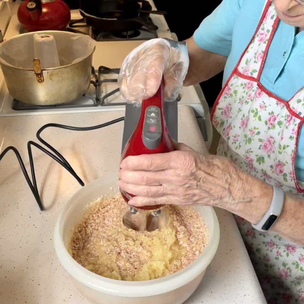 Adding fruit preserves to a jam cake batter.