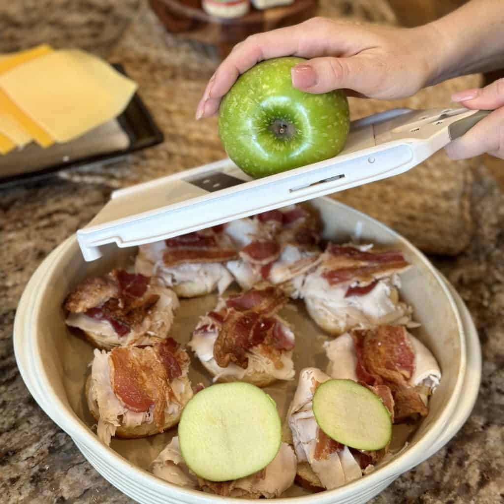 Slicing an apple across a mandolin.