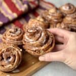 Holding an apple cinnamon crescent roll.