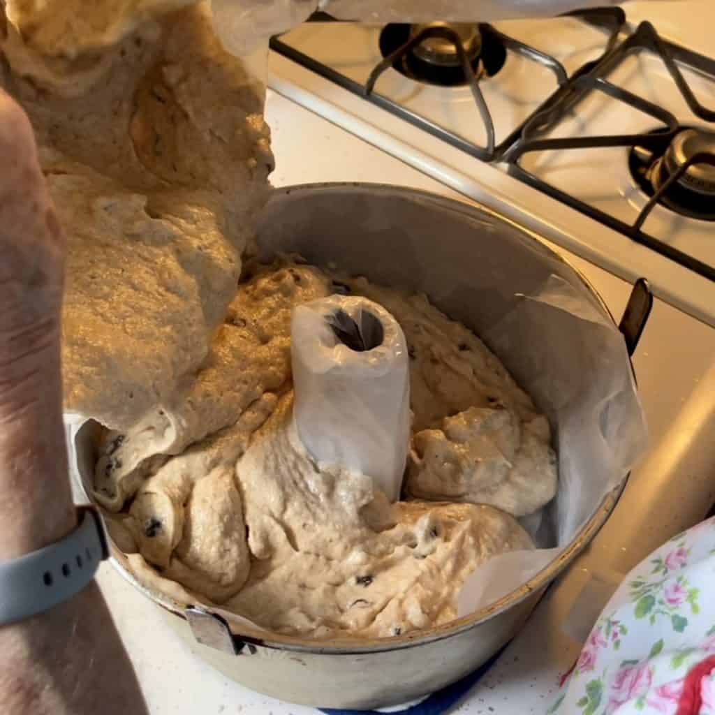 Pouring jam cake batter in a tube pan.