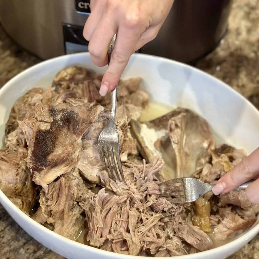 Shredding pulled pork in a bowl.