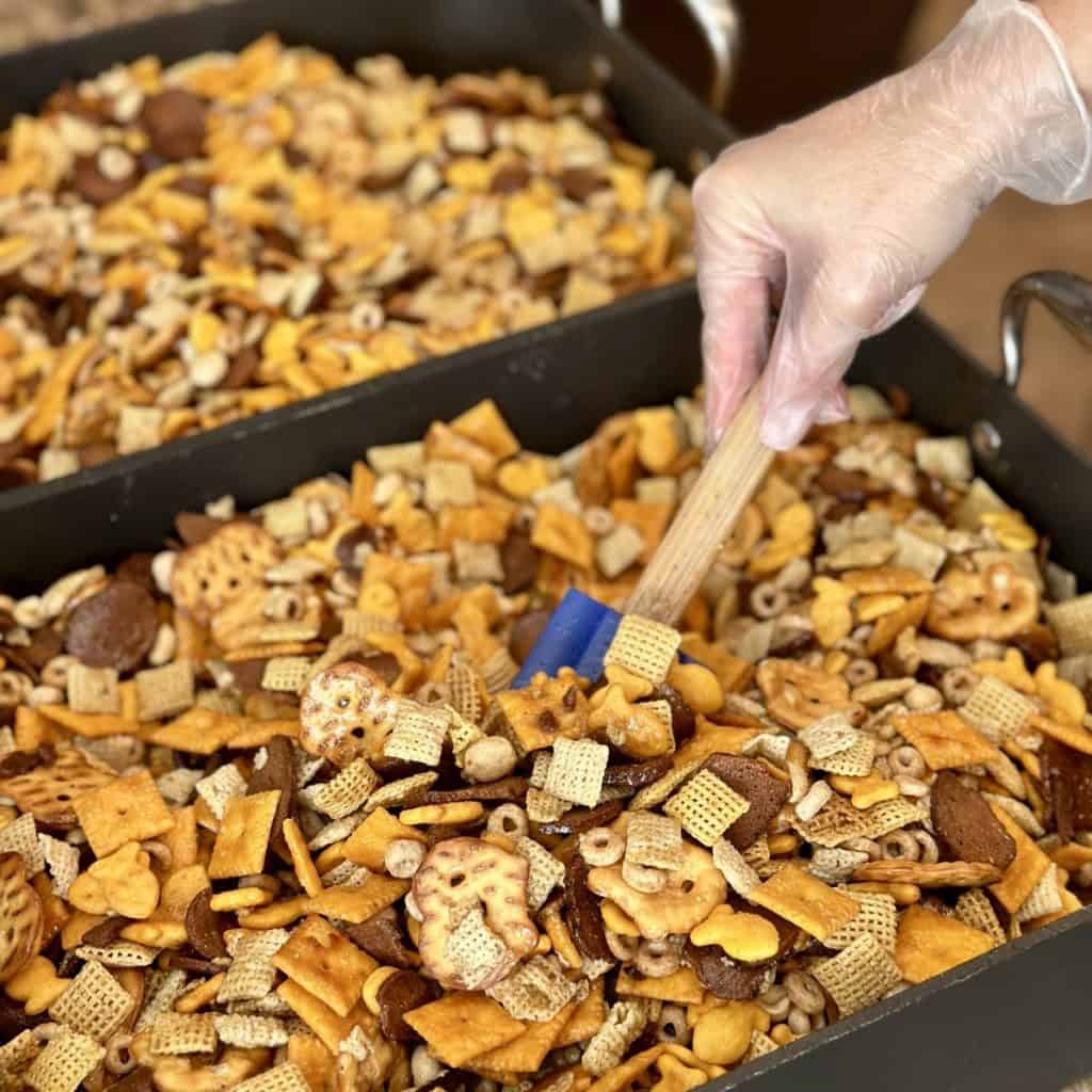 Stirring a butter sauce into chex party mix.