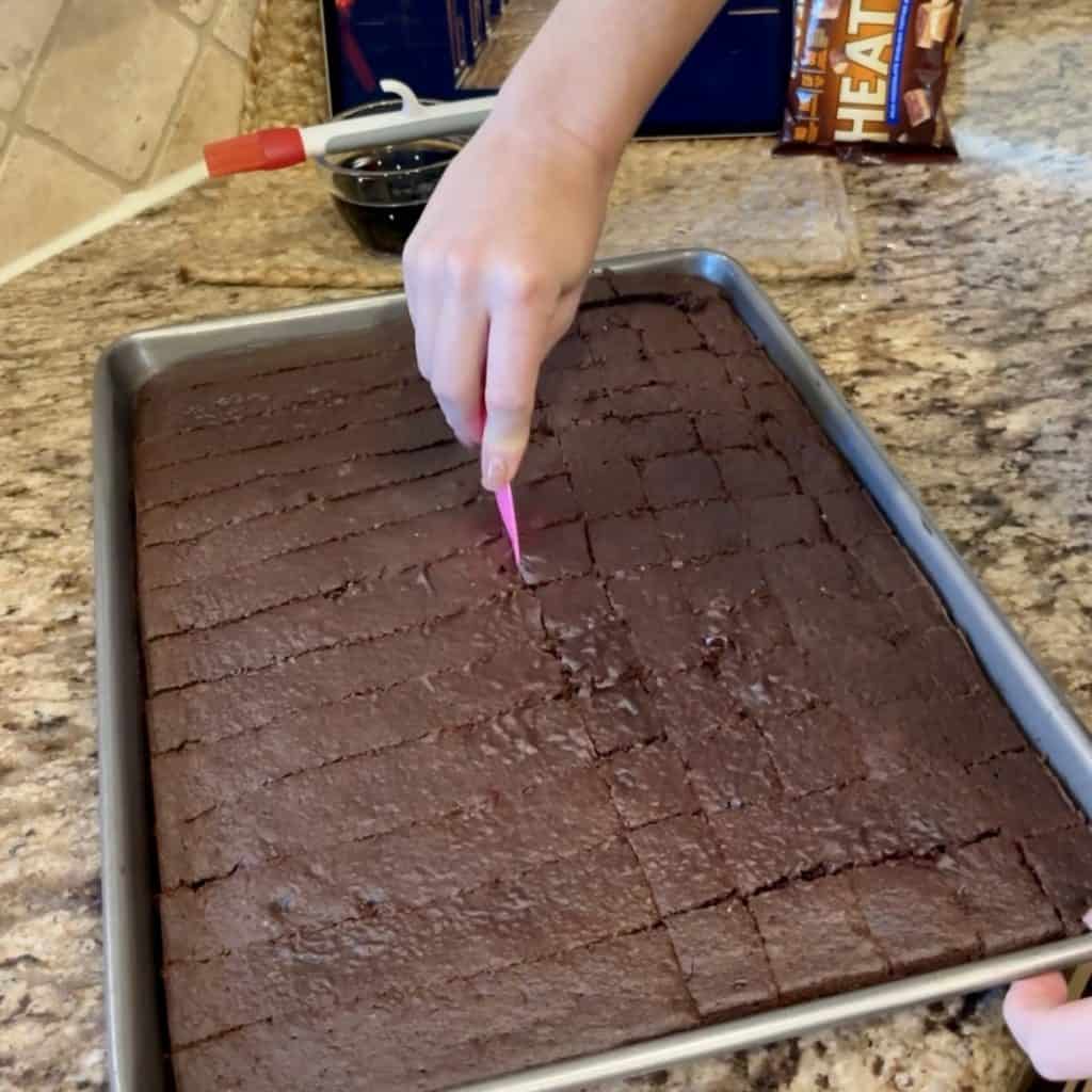 Cutting a sheet cake into cubes.