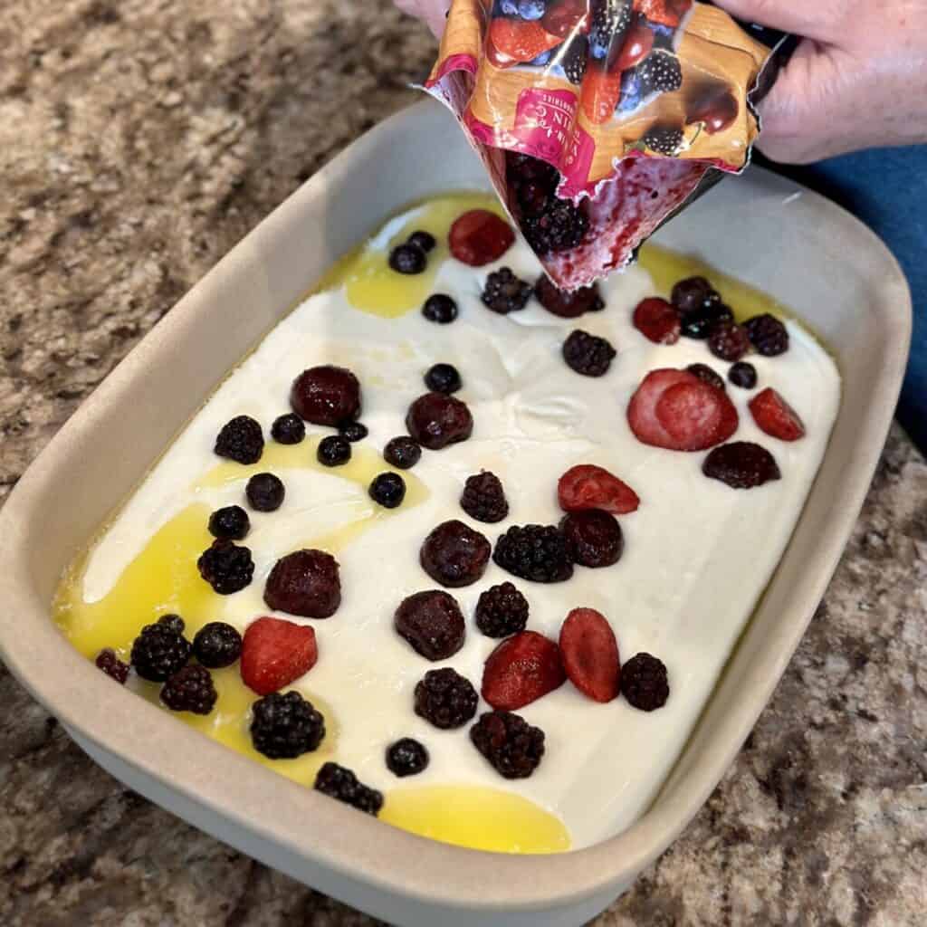 Adding fruit to a cobbler.