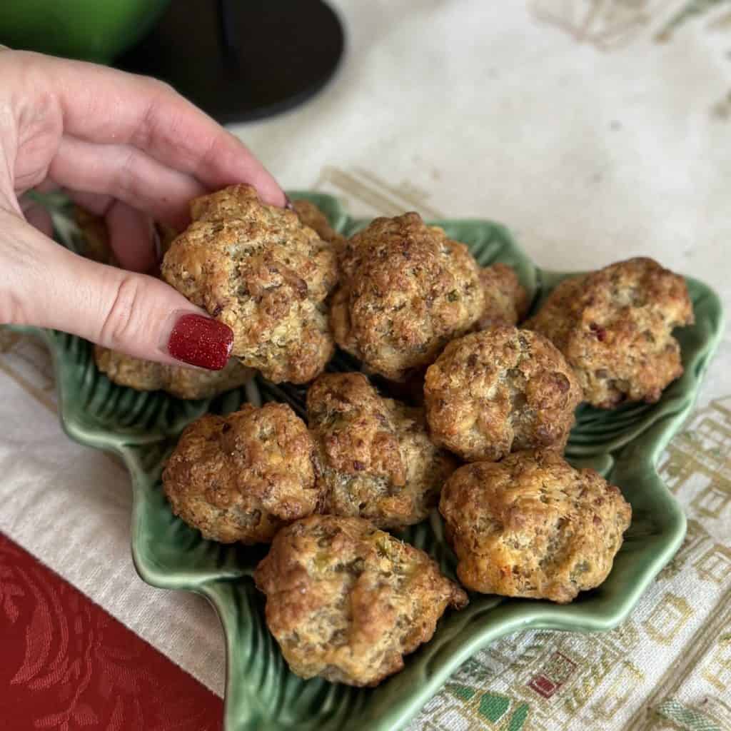 Picking up a sausage ball from a plate.