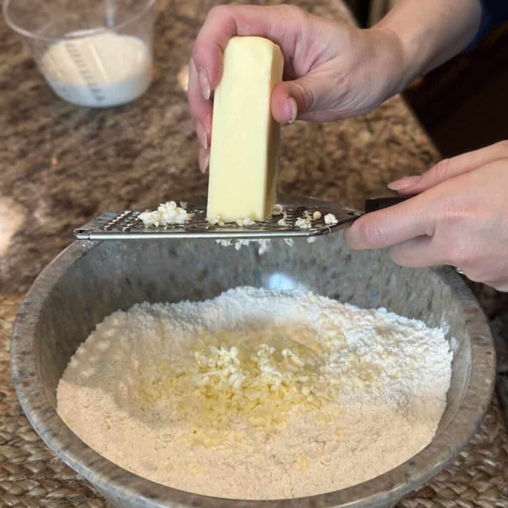 Grating butter in flour.