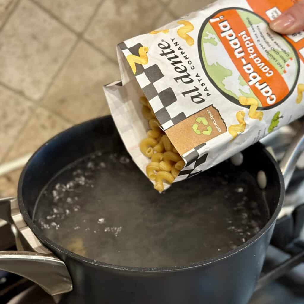 Adding pasta to boiling water.