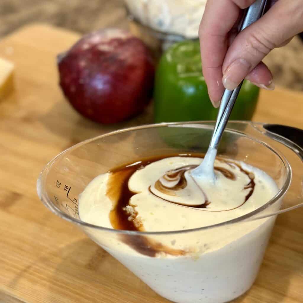 Mixing together dressing for a pasta salad.