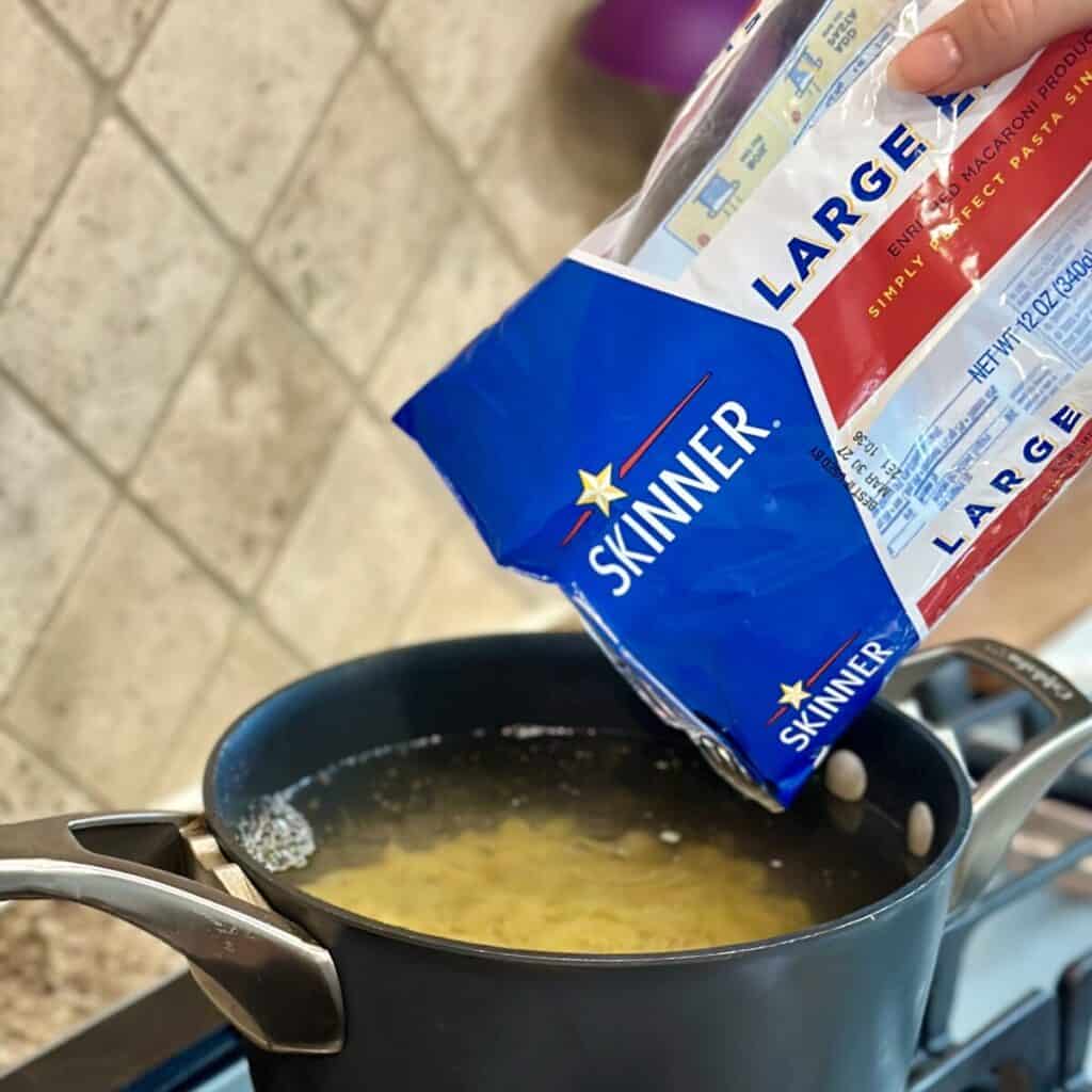 Pouring macaroni in boiling water.