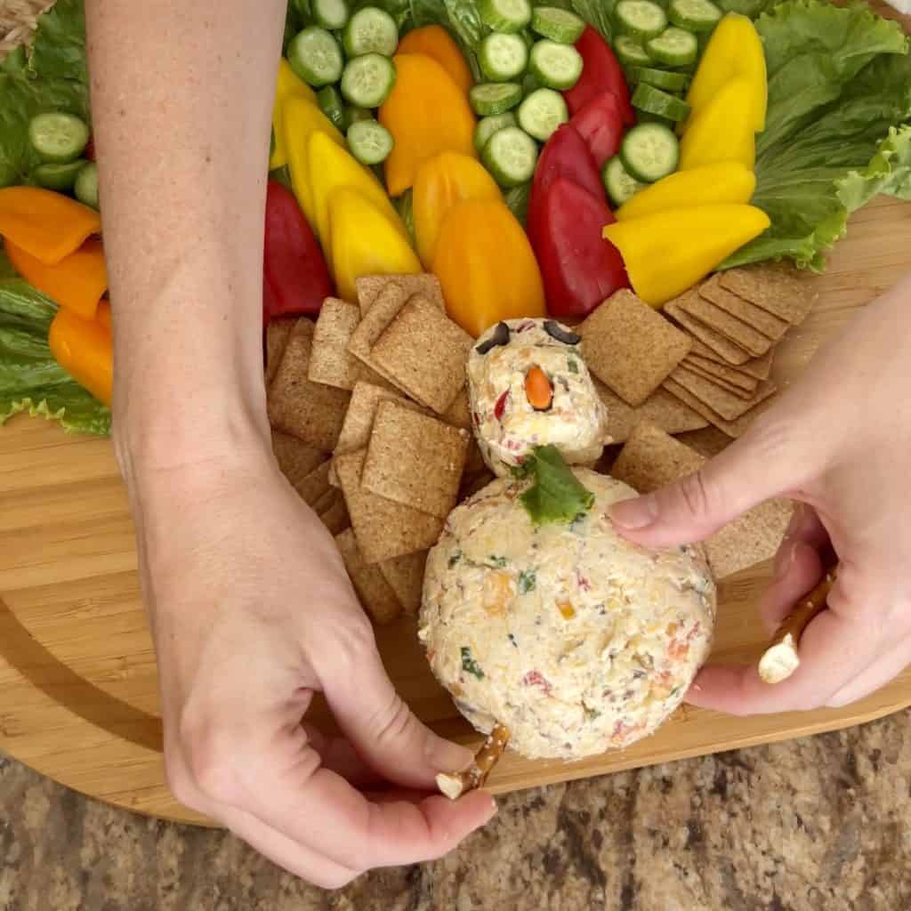 Adding accents to a cheeseball to make it look like a turkey.