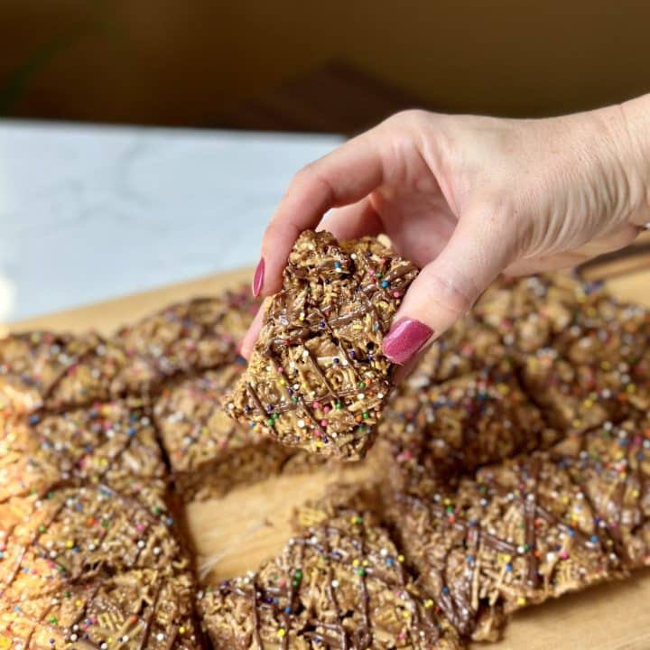 Hand holding a peanut butter hazelnut crispy treat bar.