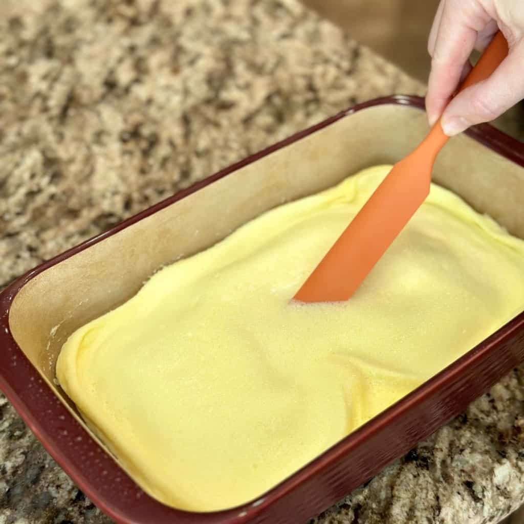 Stirring scrambled eggs in a baking dish.