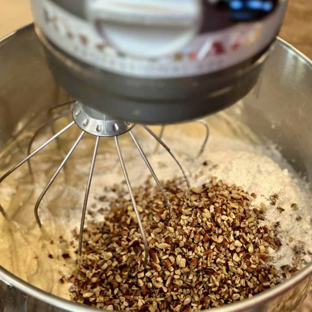 Adding flour and nuts to cake batter.