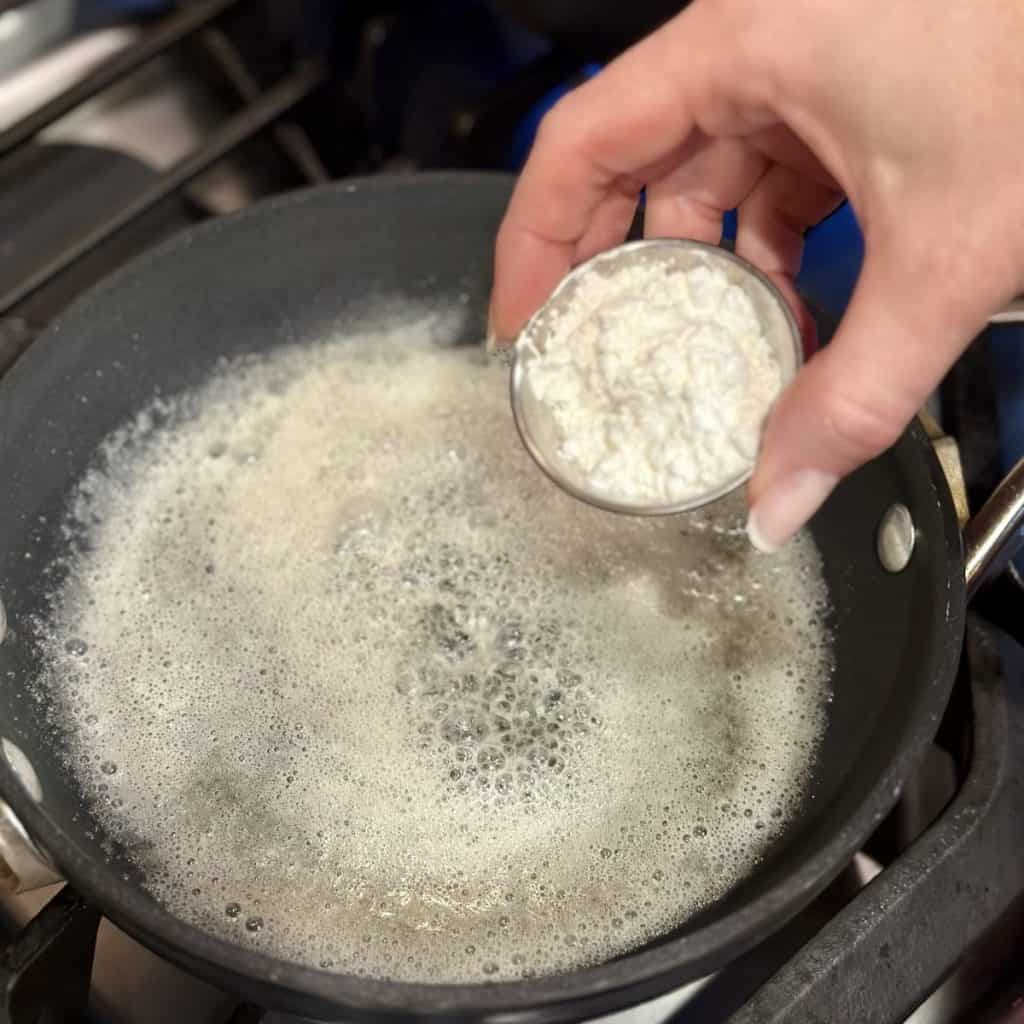 Adding cornstarch to butter in a skillet.