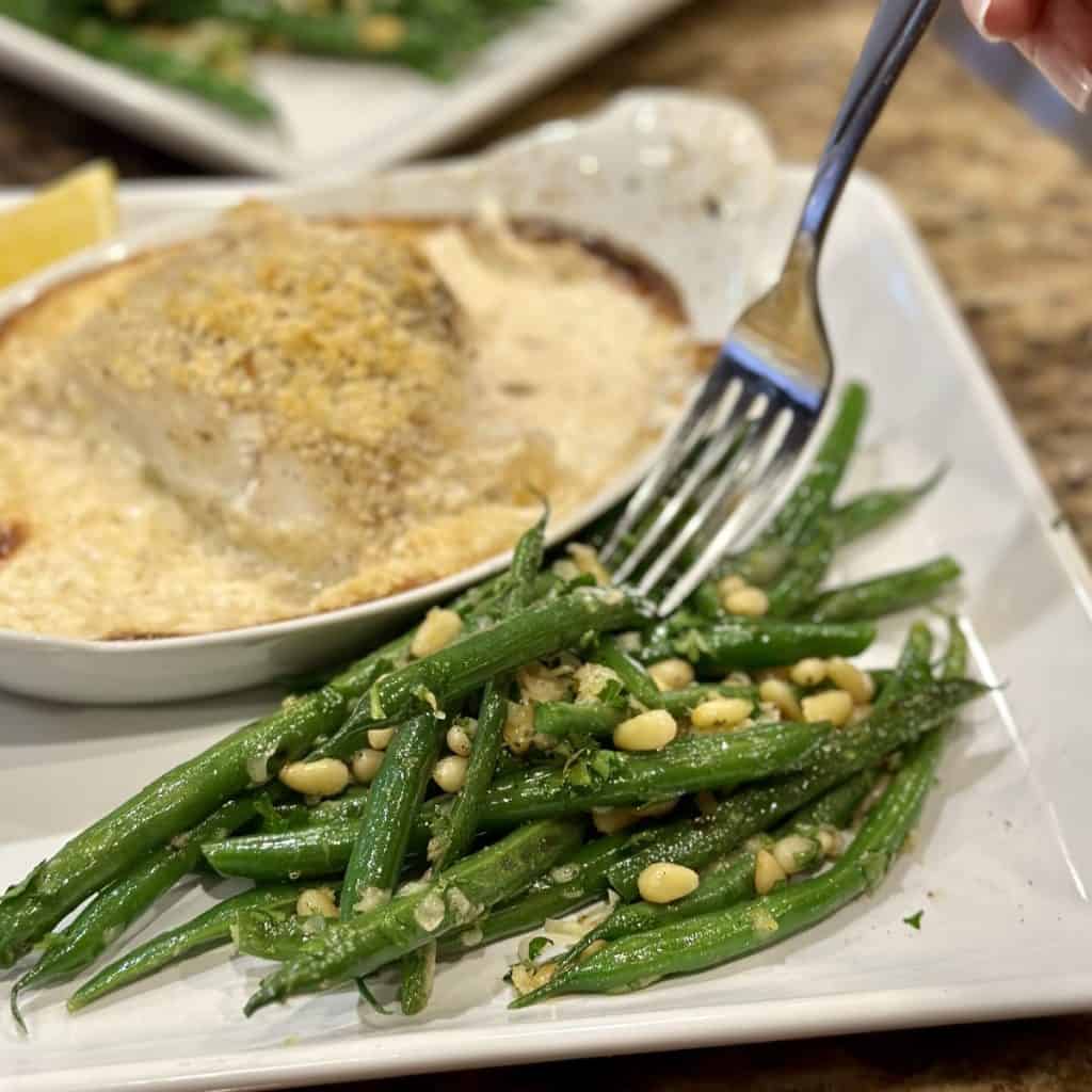 A fork getting a bite of gremolata green beans