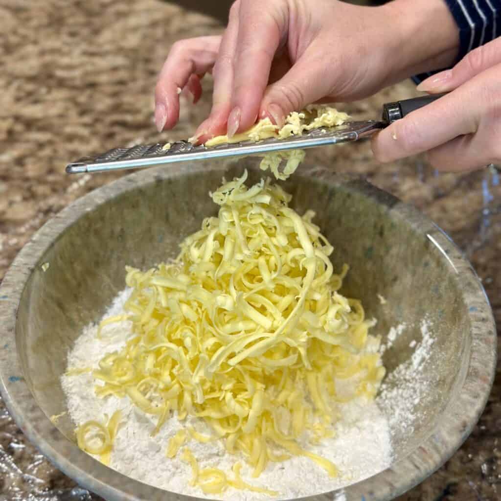 Grating butter in flour.