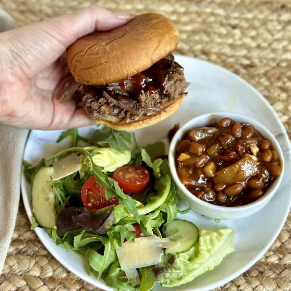 Holding a bbq brisket sandwich.