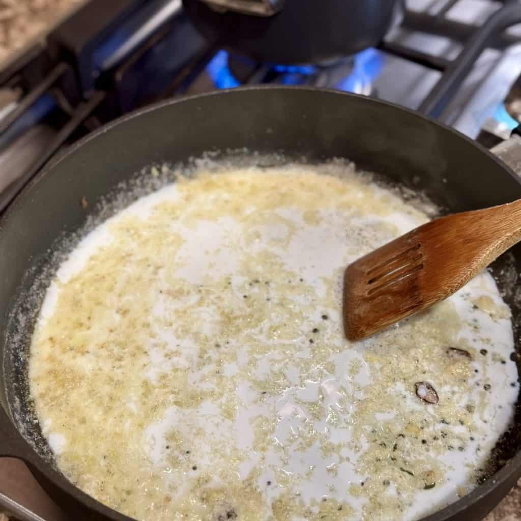 Stirring milk in a skillet.