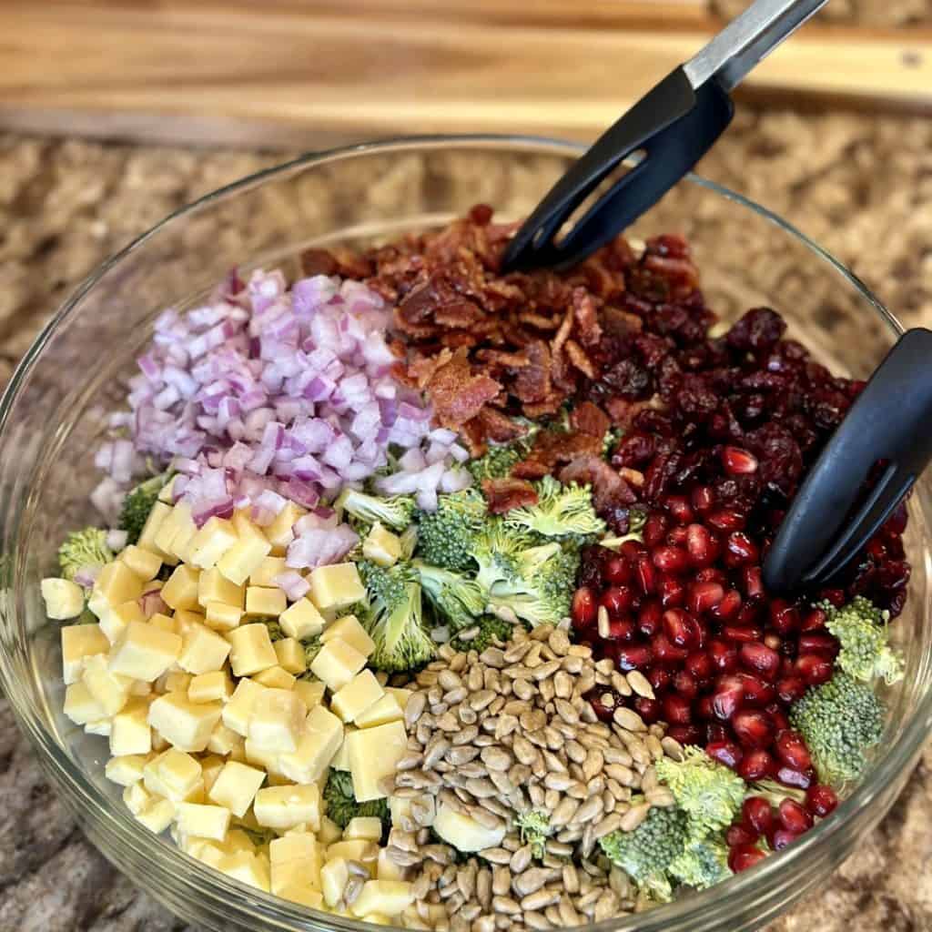 Mixing together salad ingredients for broccoli salad.