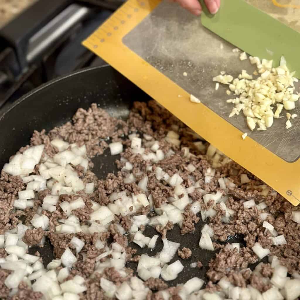 Sautéing onion and garlic with beef.