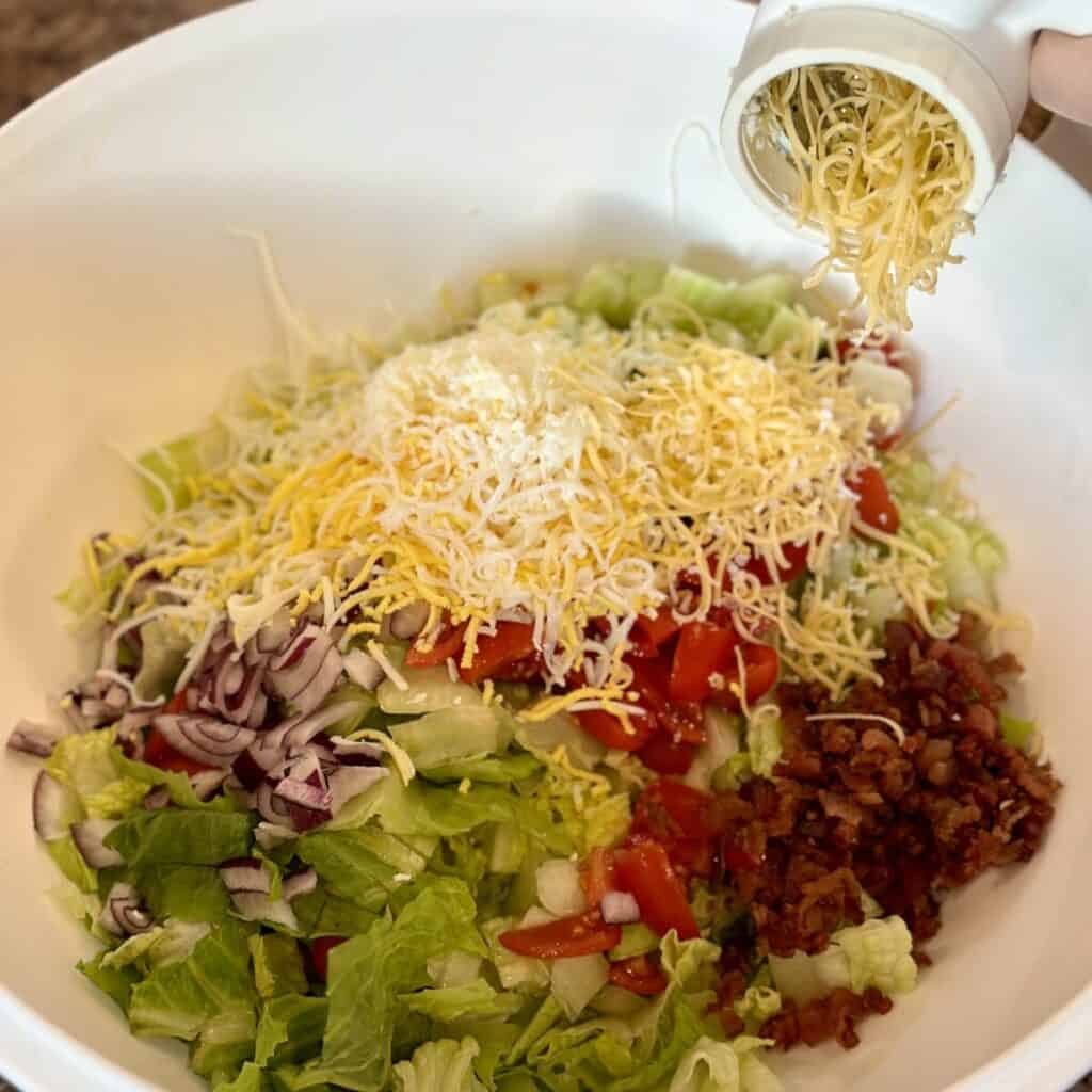 Grating cheese and boiled eggs into a bowl.