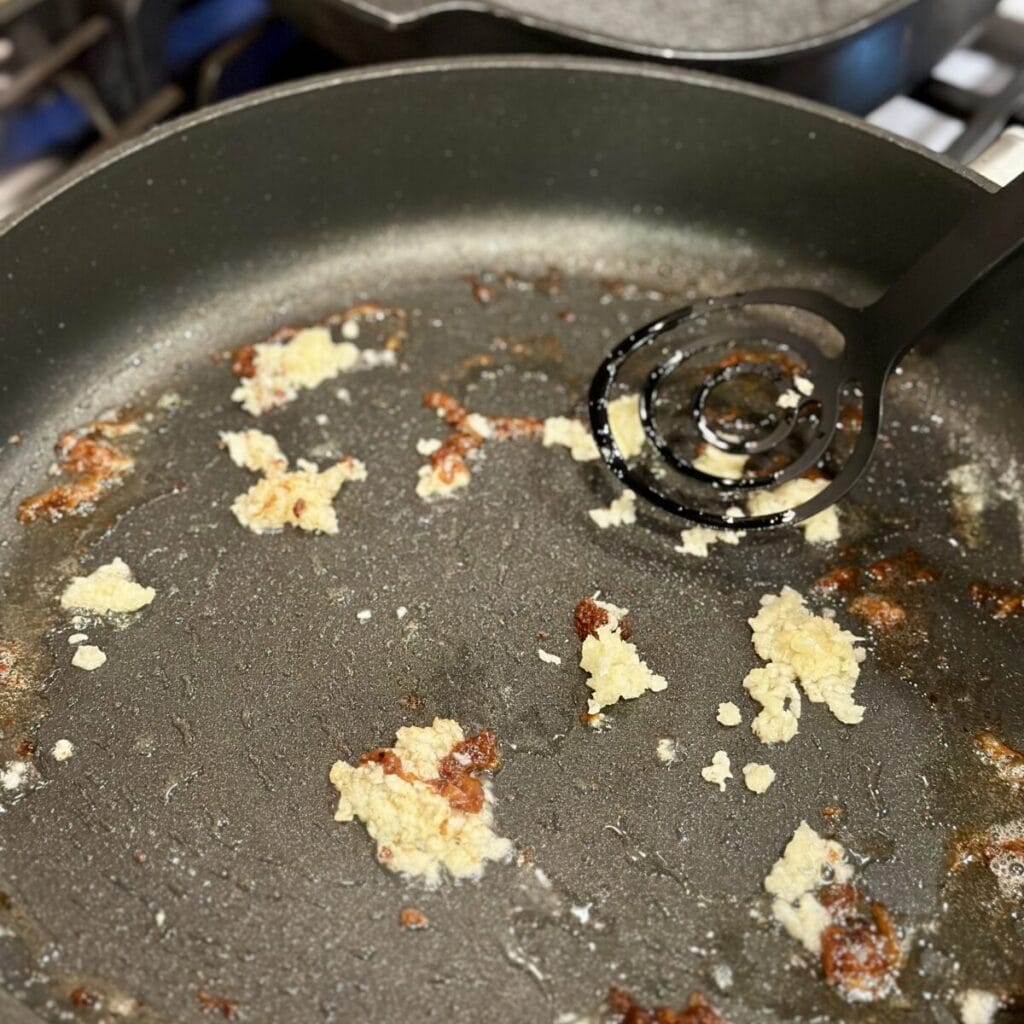 Searing garlic in a skillet.