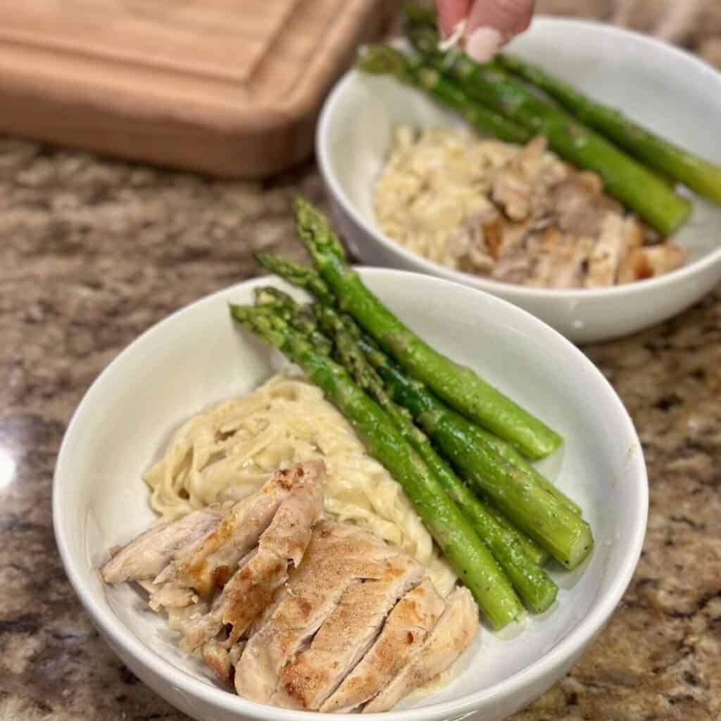 Sprinkling parmesan on pasta.