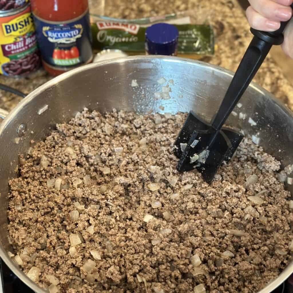 Browning ground beef and onions in a skillet.