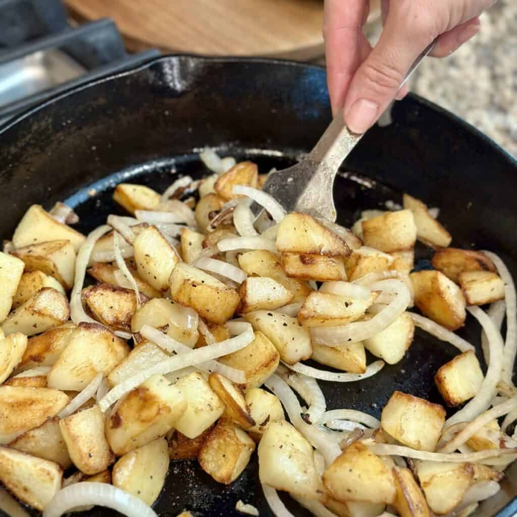 A skillet of cooked potatoes and onions.