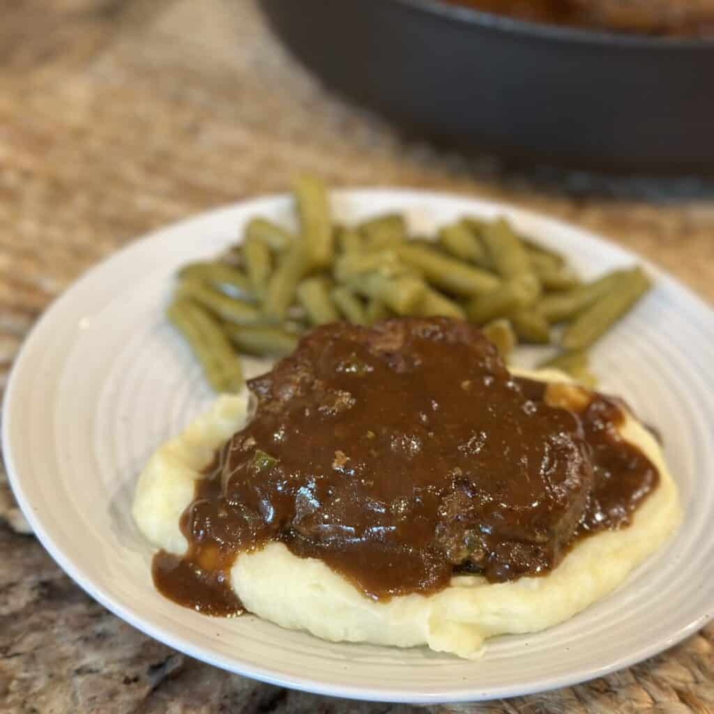 Hamburger steak and gravy on a plate.