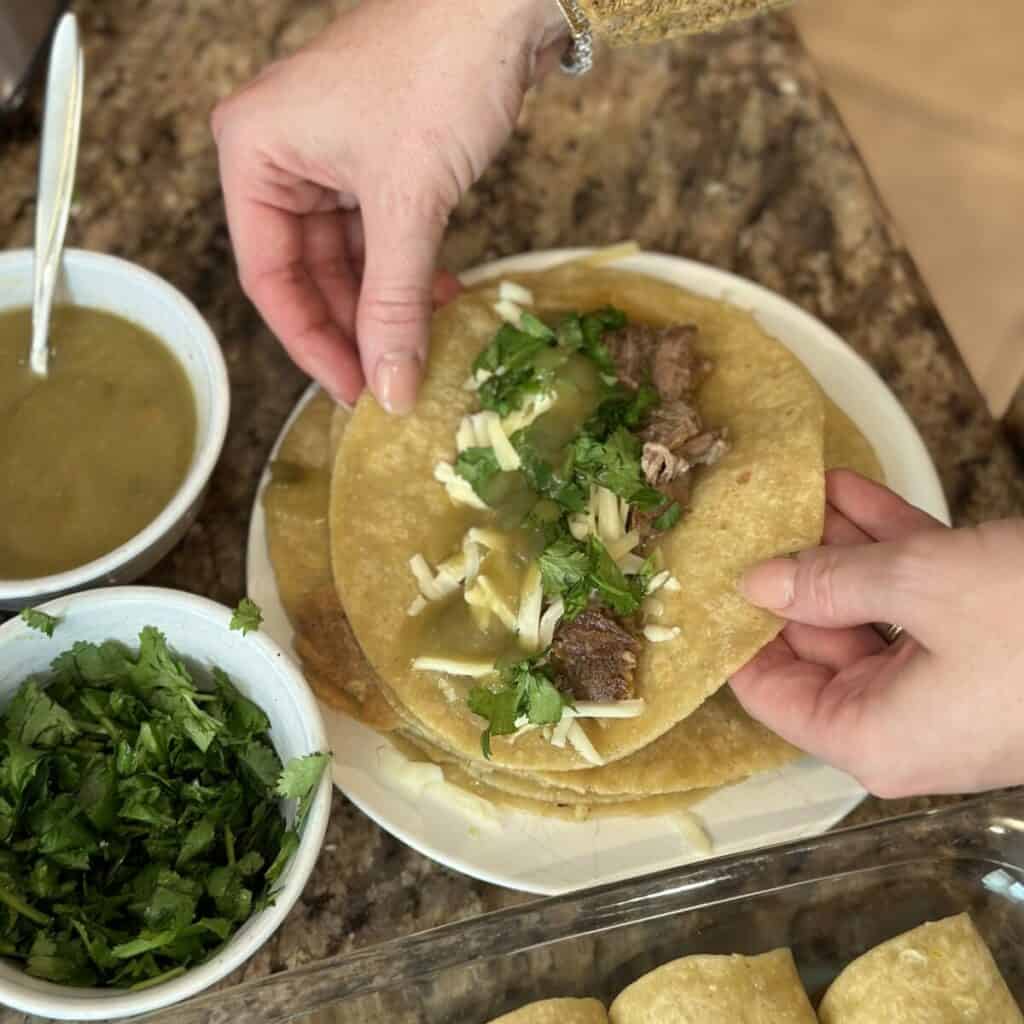 Filling a tortilla with pork and cheese.