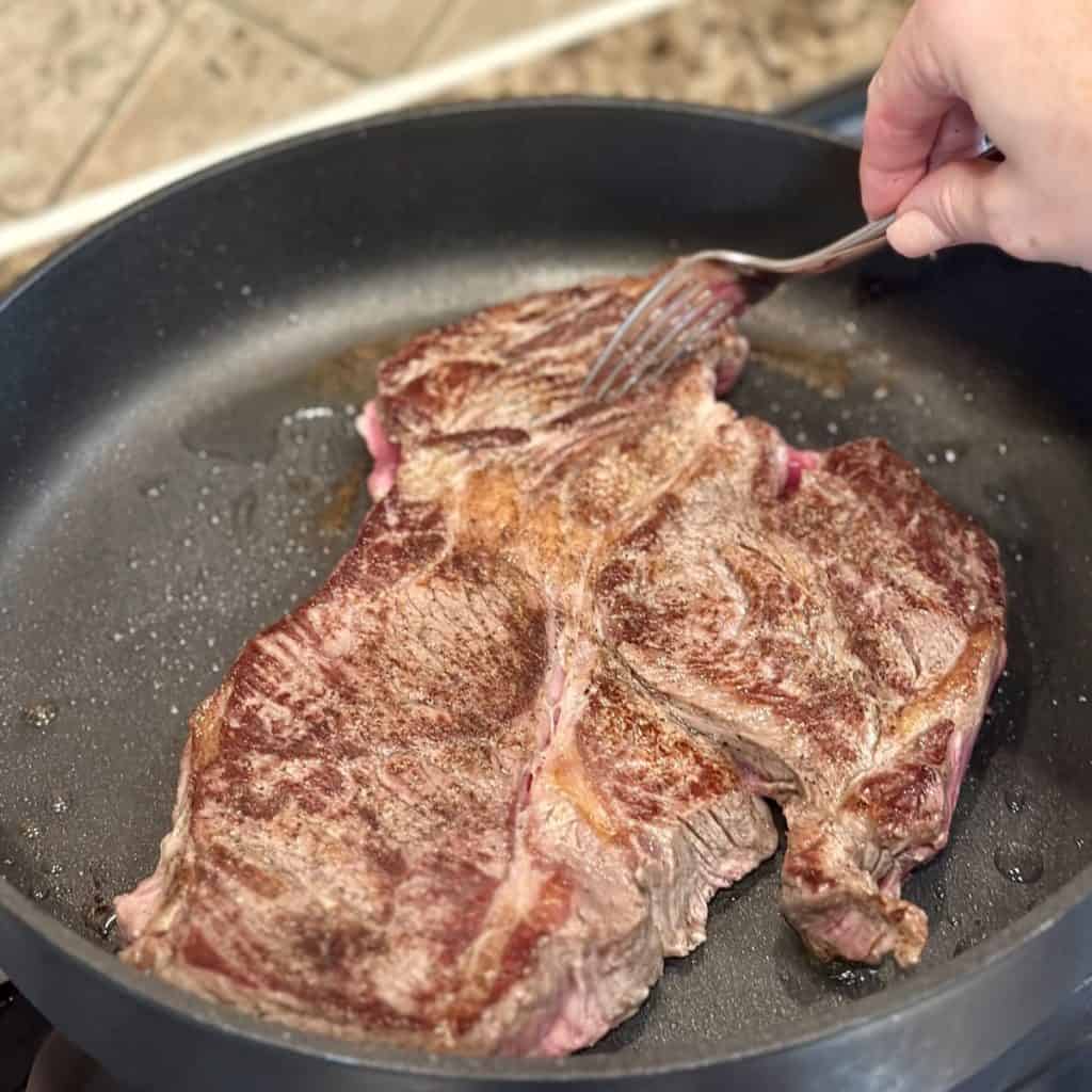 Searing a roast in a skillet.