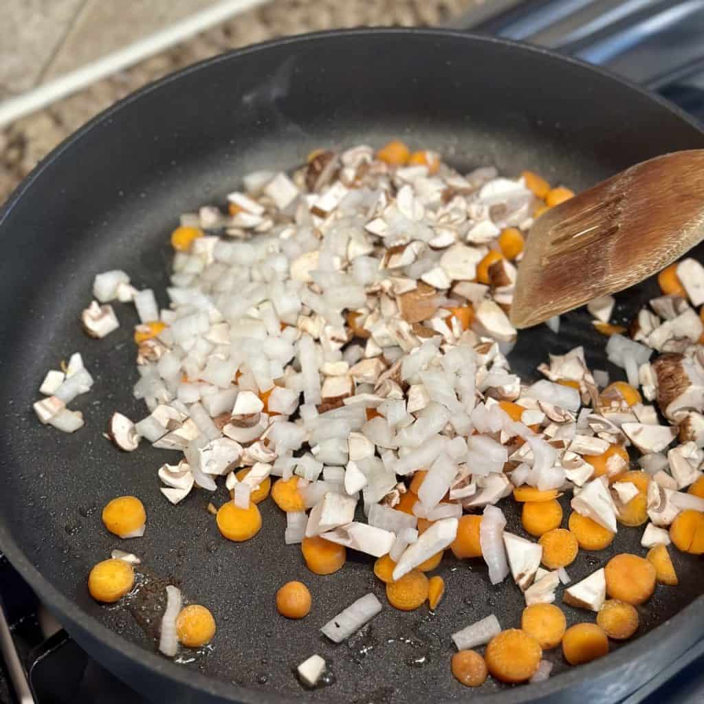 Sautéing chopped veggies in a large skillet.