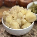 This is a picture of a bowl of boiled potatoes with black pepper on top.