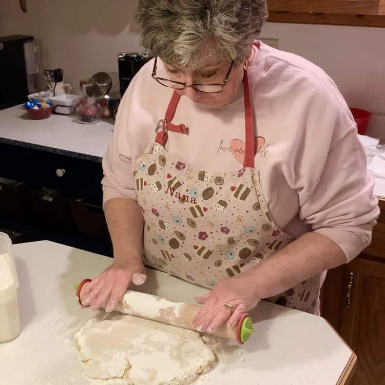 using a rolling pin to roll out the cookie dough