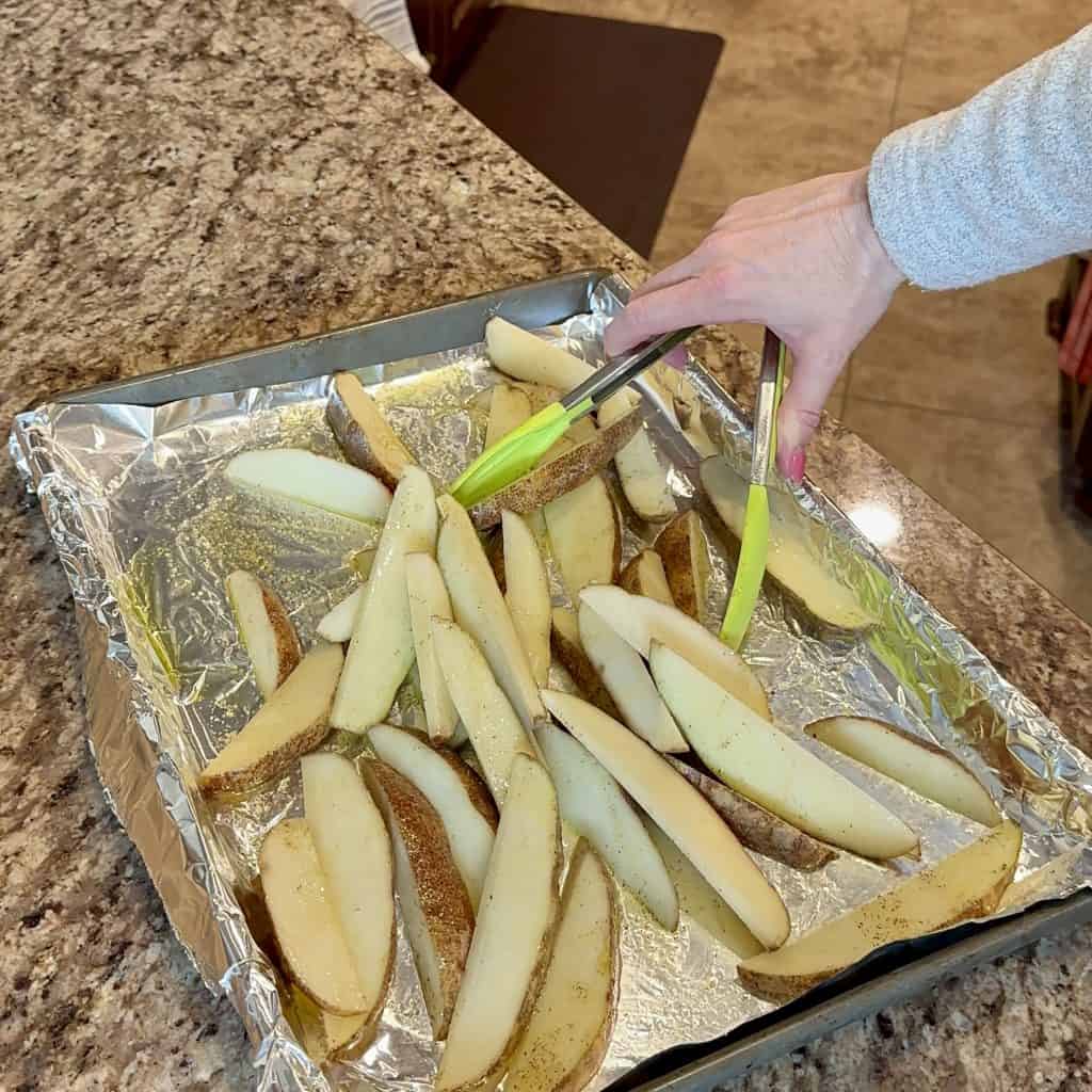 laying potato spears on a sheet pan