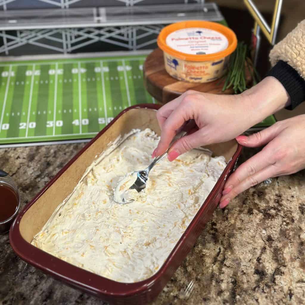 spreading the cream cheese mixture in the baking dish