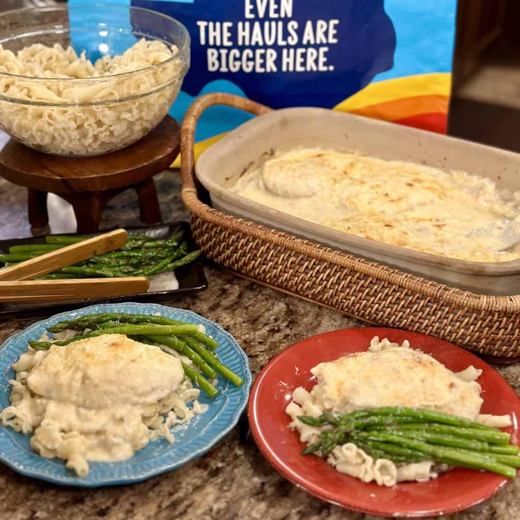 two plates of chicken and sauce with asparagus spears