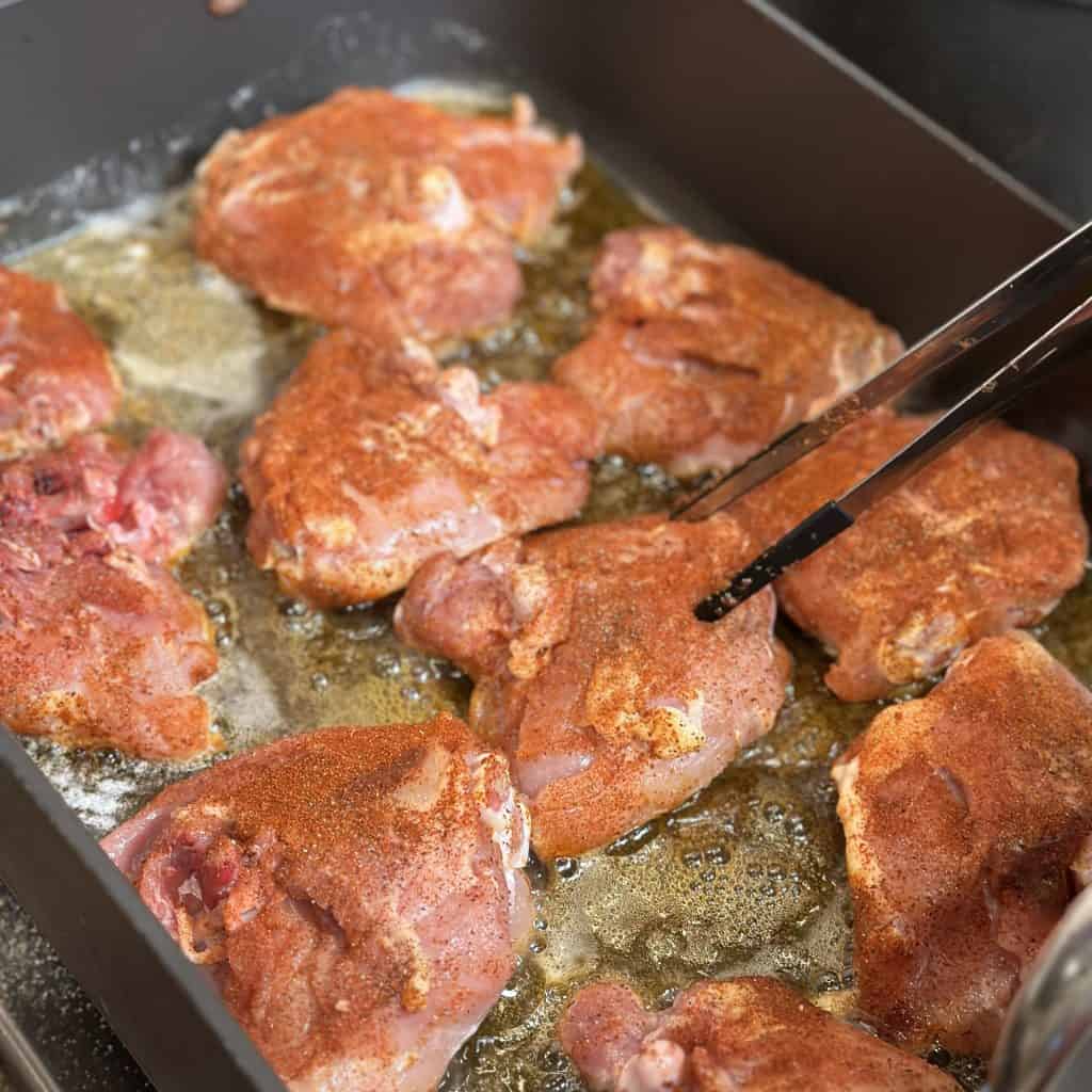 cooking the chicken in a pan with oil to fry