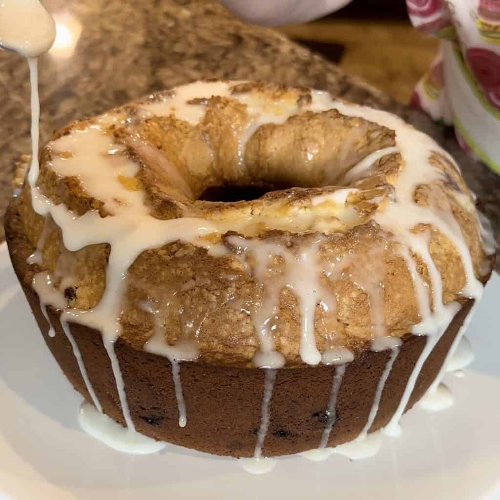 Adding glaze to the top of pound cake.