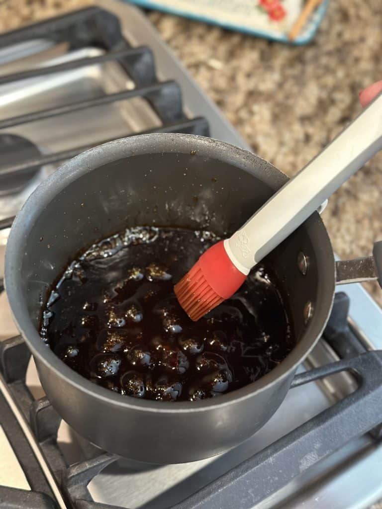 Glaze for meatball skewers boiling in a saucepan.