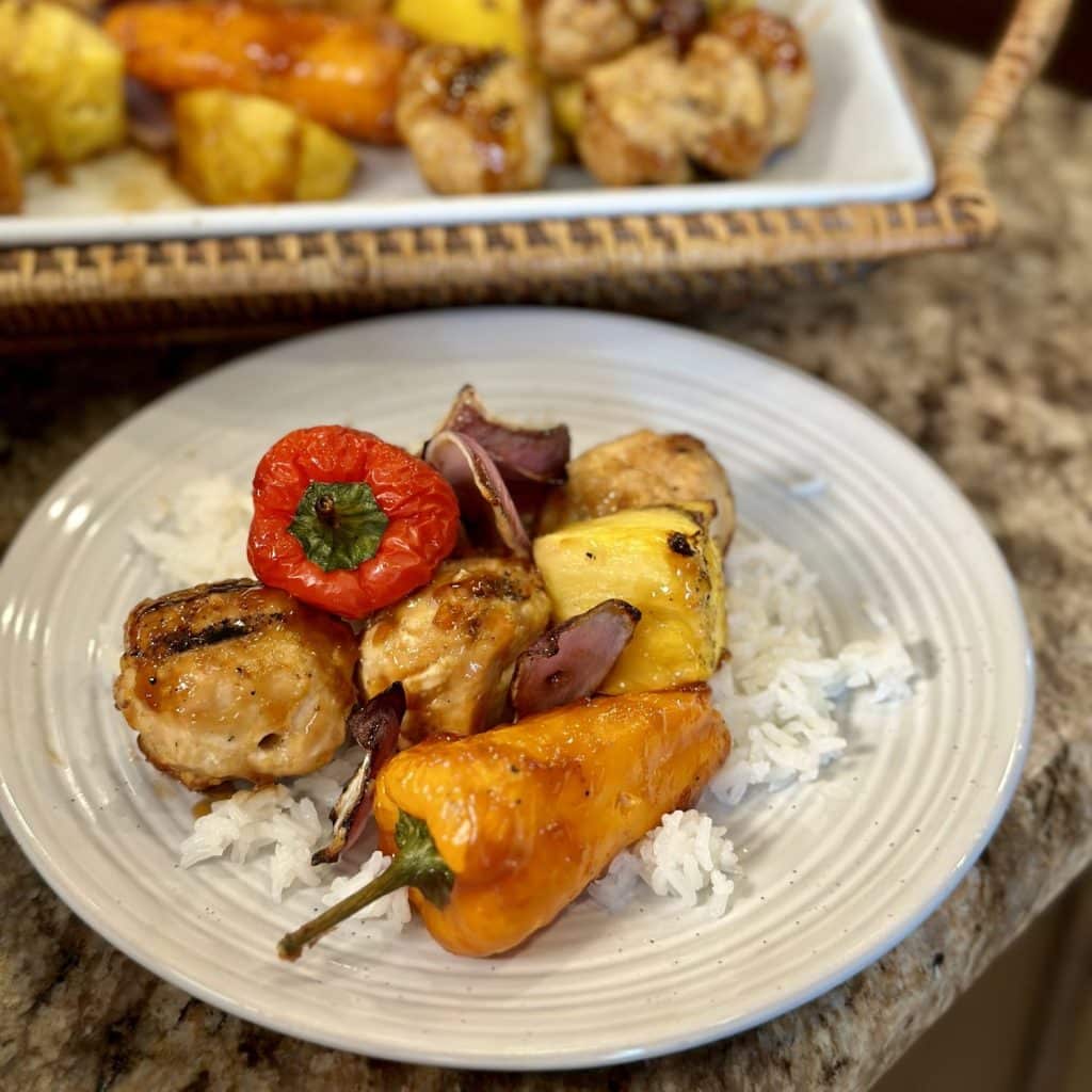 Chicken meatballs, peppers, pineapple, and onions over rice.