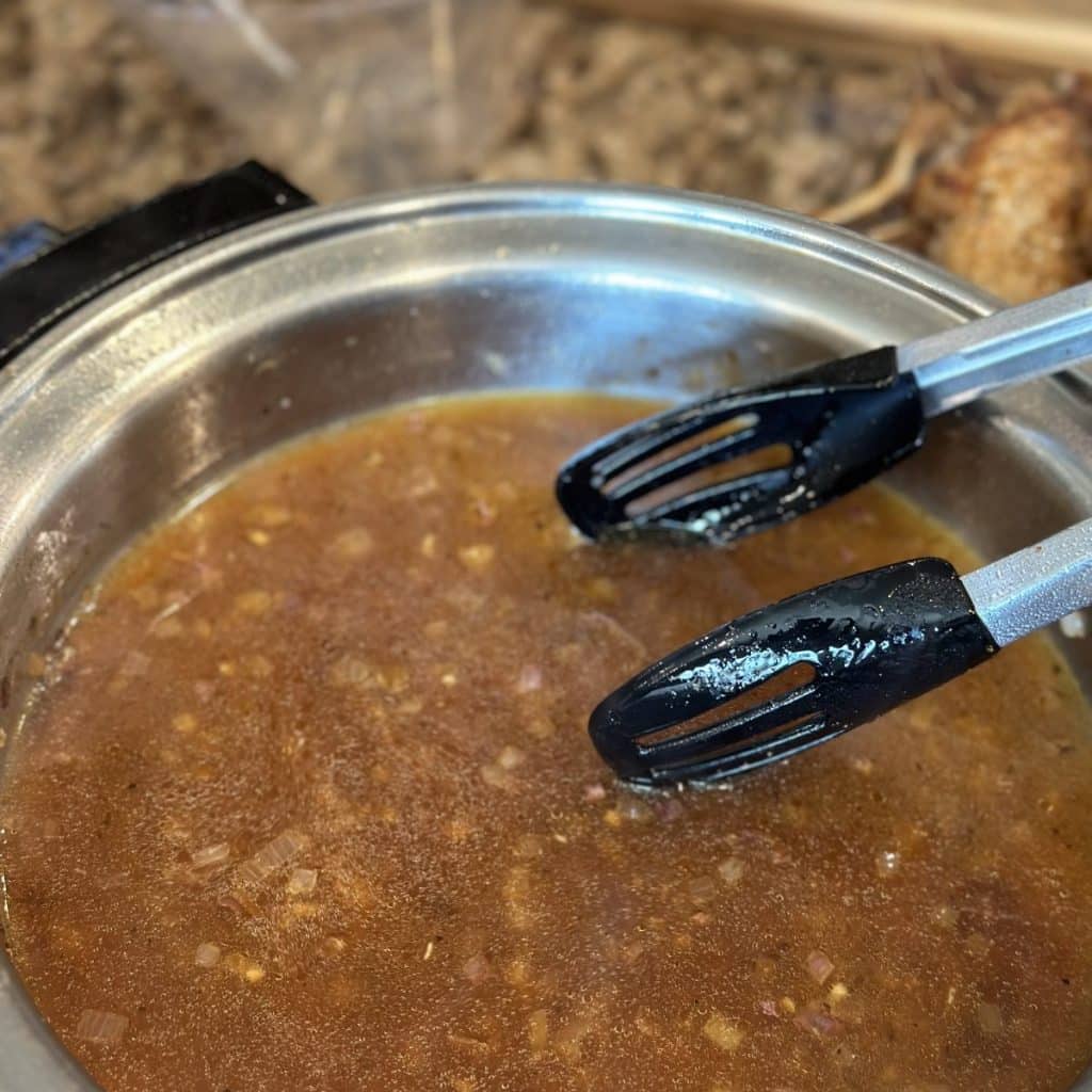 Chicken broth sauce simmering in a skillet.