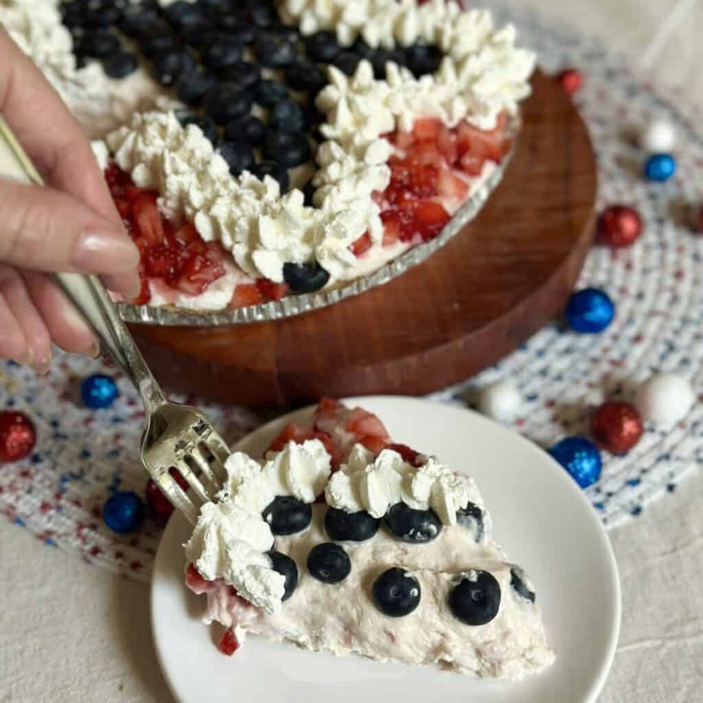 Getting a forkful of berry cheesecake pie.