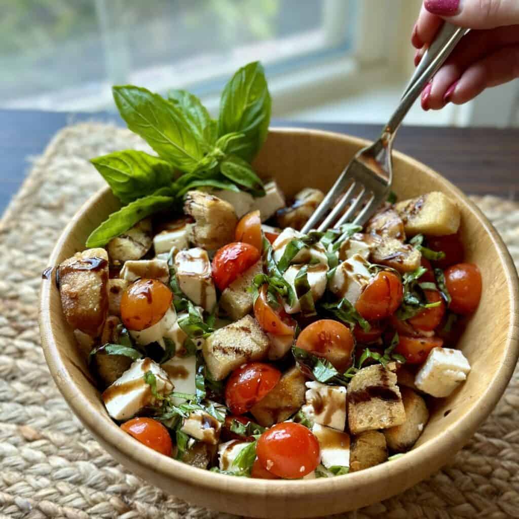 Getting a forkful of caprese panzanella salad.