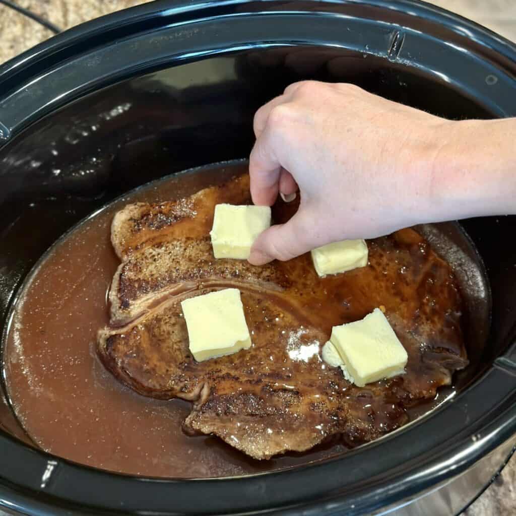 Adding butter to the top of roast beef.